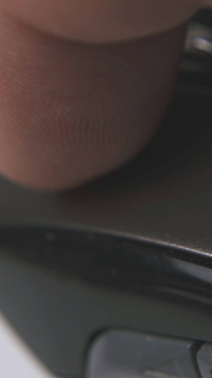 man clicks button on modern computer mouse with wheel on white background extreme close view
