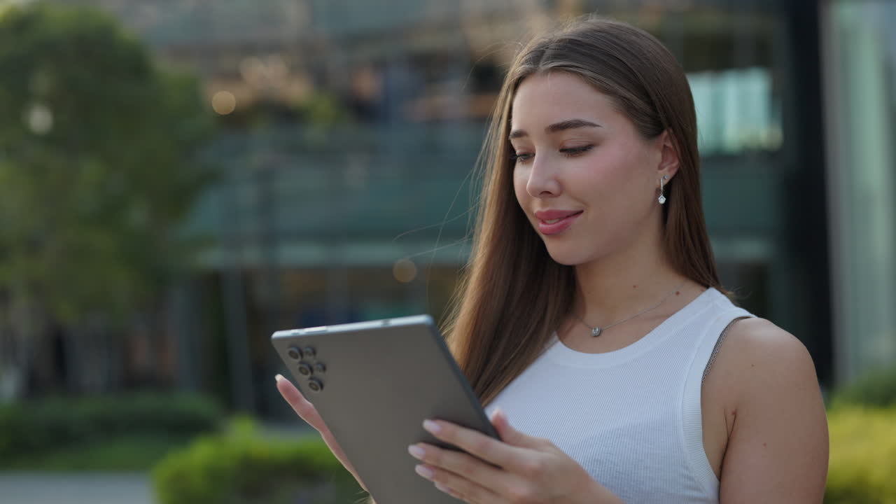 женщина, использующая планшет на открытом воздухе