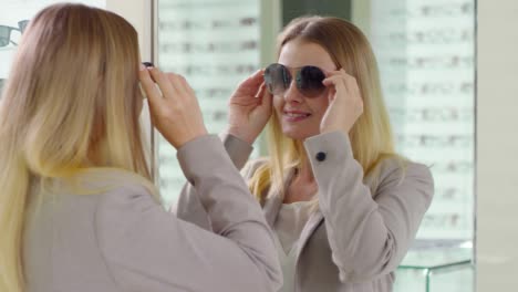 mujer probando gafas de sol en una tienda de óptica