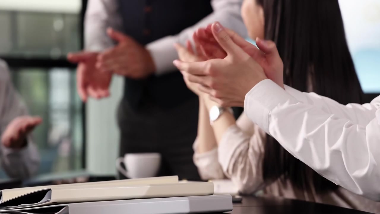 Group of excited team professionals business people applauding colleague after successful presentation or achievement. Happy coworkers celebrating shared success during a meeting in startup office