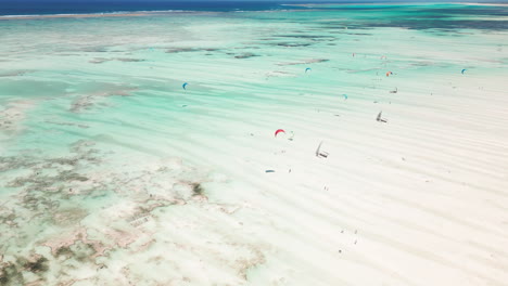 Luftaufnahme-Von-Kitesurfern,-Die-über-Türkisfarbenes-Wasser-Gleiten