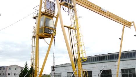 grúa de pórtico amarilla en una fábrica suburbana