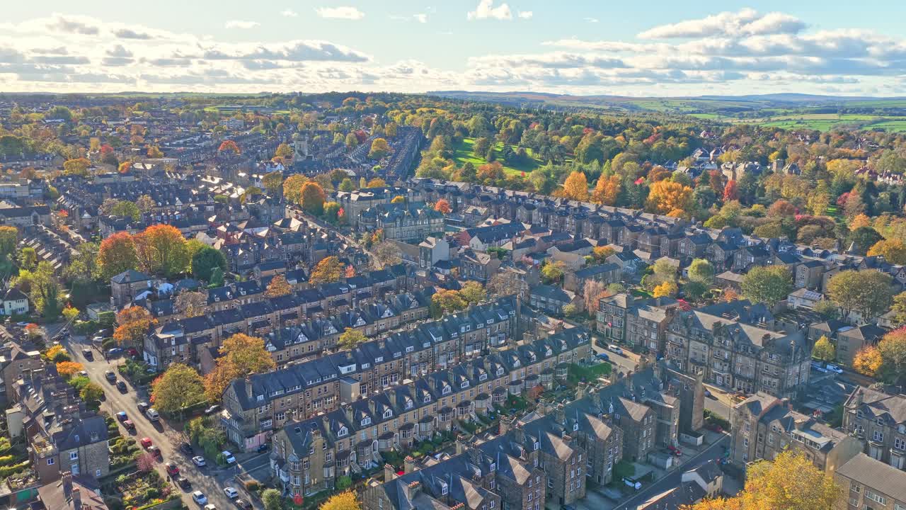 Aerial panoramic view over Harrogate, North Yorkshire, shows a grid of stone-built Victorian and Edwardian terraces surrounded by mature trees in peak autumn color
