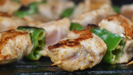 closeup of chicken and green pepper skewers on a grill