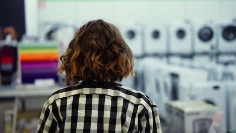 Rastreando-Imágenes-Raras-De-Una-Chica-Con-Una-Camisa-A-Cuadros-Y-El-Pelo-Corto-Caminando-Por-Un-Supermercado-En-Electrodomésticos-Buscando-Algo