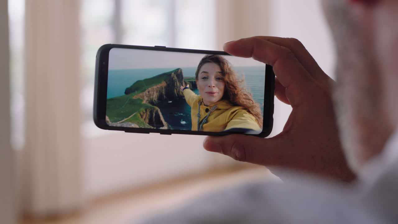 hombre joven chateando en video con su novia en el teléfono inteligente saludando con la mano mujer joven compartiendo vacaciones en escocia pareja de viaje que tiene una relación a larga distancia