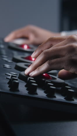 hands on an audio mixing console