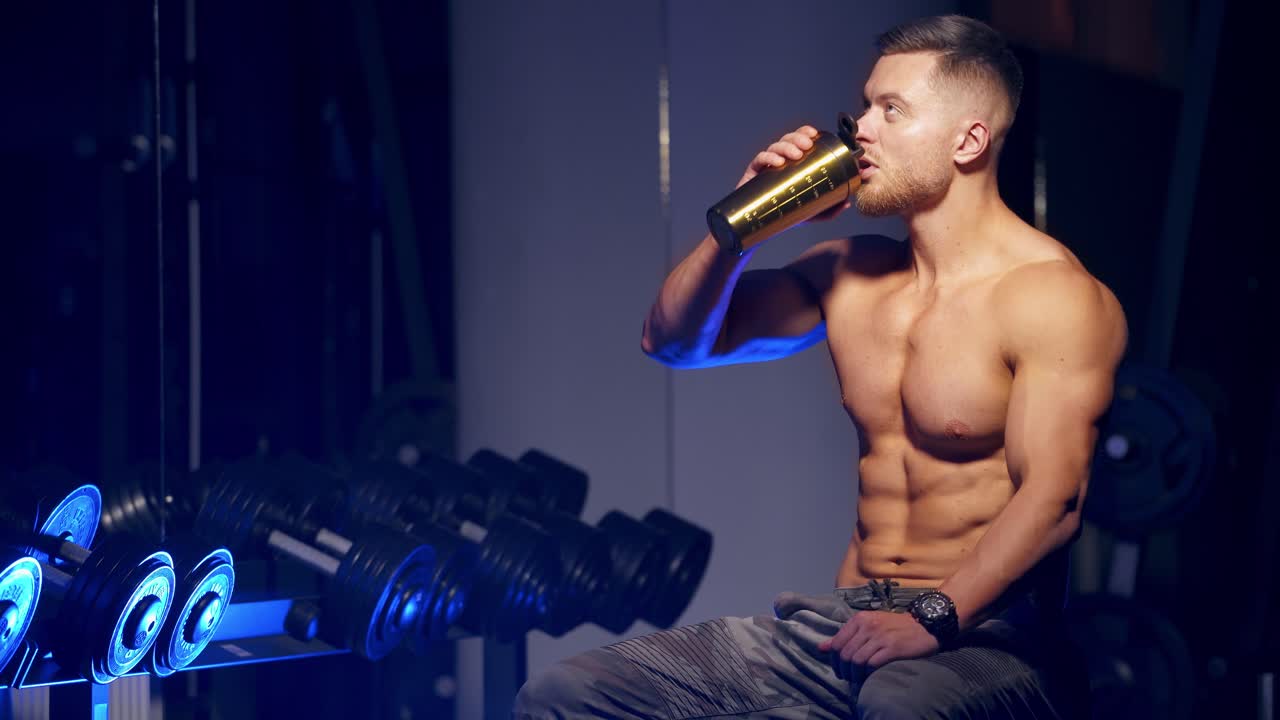 Muscular Man Resting After Exercise. Muscular caucasian man drinking protein powder from shaker after exercise