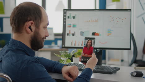 trabajador independiente con discapacidad hablando por videoconferencia con una pareja femenina a distancia