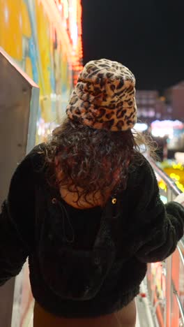 person wearing leopard print bucket hat and fuzzy jacket at night