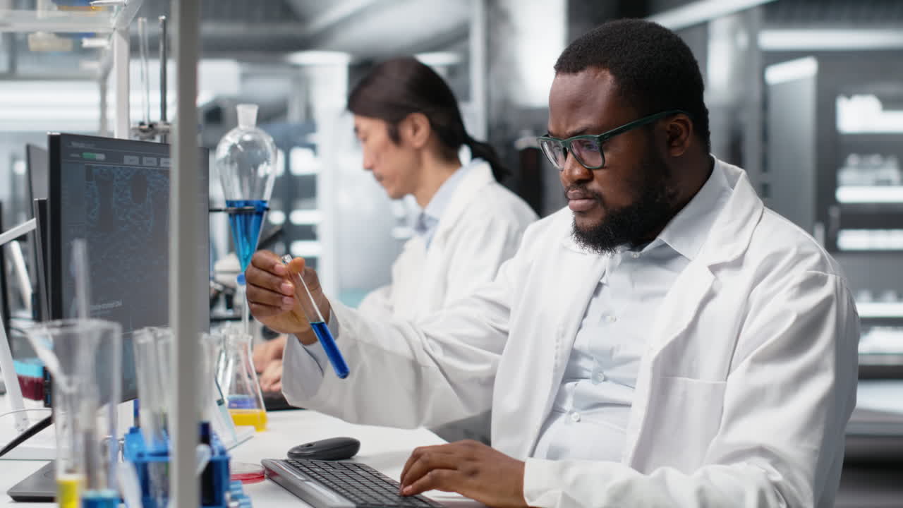 Vertical video Medical technician investigates chemical sample properties using PC software