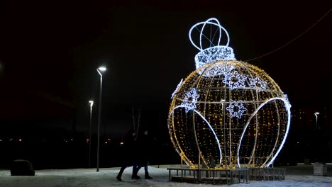 giant christmas ornament decoration in a park at night