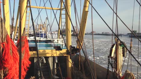 pov fishing boat preparing to dock in a frozen harbor on a sunny winter day