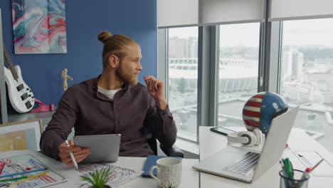 contemplative designer looking solution at home close up. man holding tablet