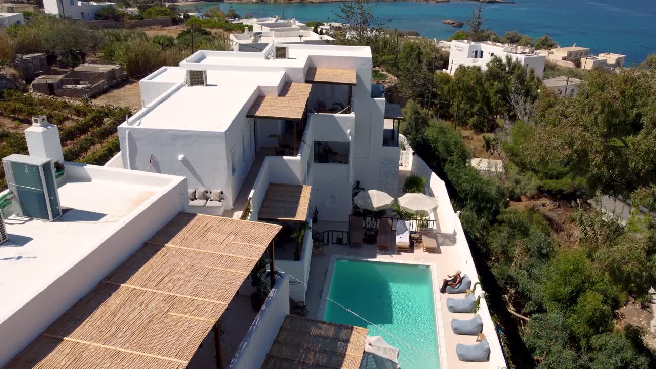 Aerial over Parea Hotel Terrace and Charming Woman Seating and Relaxing, Paros