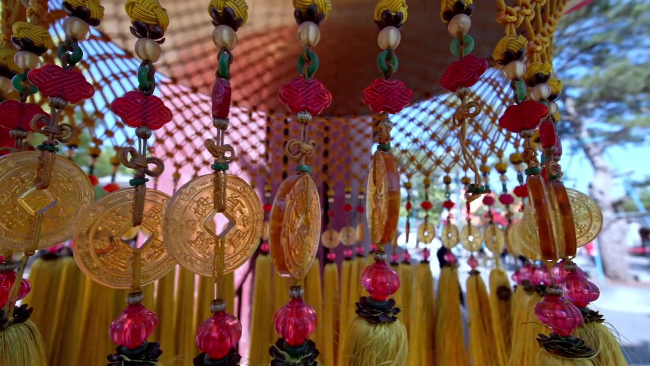 Monete d'oro e nappe vivaci ondeggiano dolcemente in un padiglione di Shanghai. Ideale per documentari culturali o servizi di viaggio.