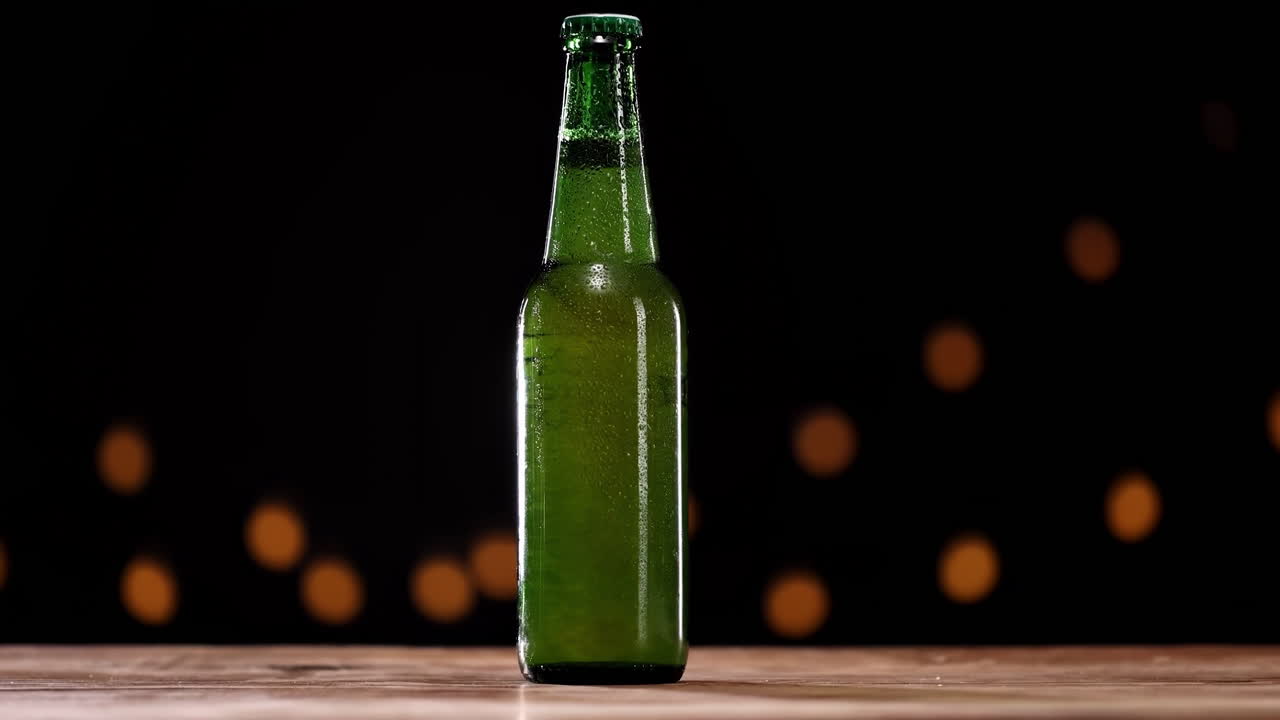 Botol bir gandum atau lager hijau dingin dari lemari pendingin, tetesan kondensasi menutupi permukaan wadah, menonjolkan kualitas yang menyegarkan dan renyah, terisolasi dengan latar belakang hitam.