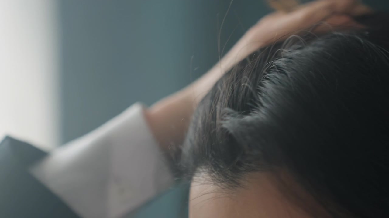 Closeup hair detail. Fingers trace hair with gentle light. Intimate shot emphasizing hair texture and movement. Close perspective highlighting scalp details under soft natural lighting