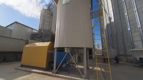 metal equipment on the large agricultural factory. exterior of agricultural complex with huge grain elevators. modern processing plant.