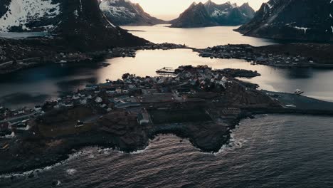 snowy mountain by the sea at sunrise in reine village, norway. - aerial shot
