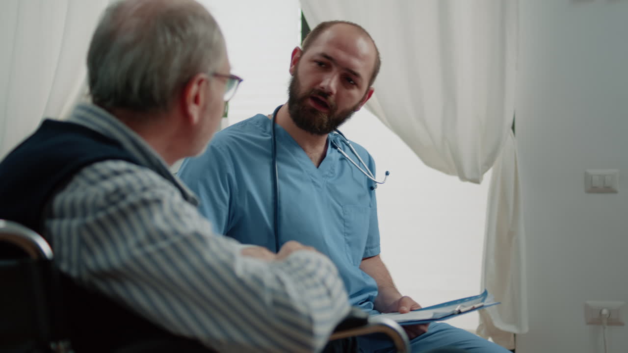 Medical assistant consulting old man with disability