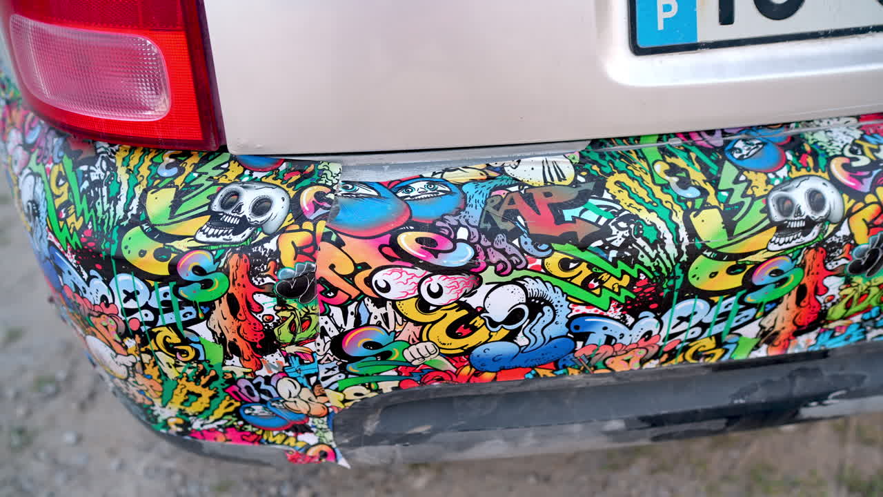 Car bumper showcasing vibrant, colorful graffiti stickers