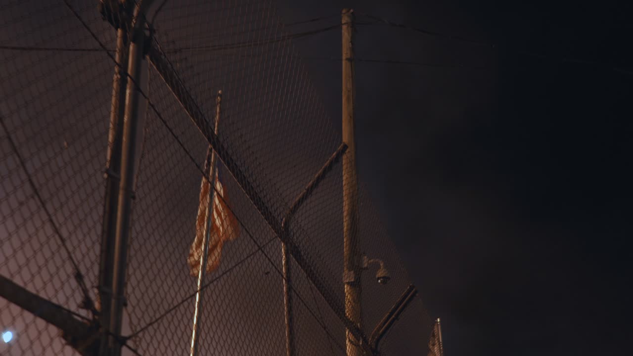 bandera americana ondeando detrás de una valla rodeada de humo por la noche