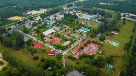 Cinematic-Drone-Footage-of-Palm-Oil-Mill-Effluent-residential-consists-of-buildings,-homes,-main-road-and-infrastructure-surrounded-by-palm-oil-trees-deforestation-located-in-Indonesia-in-full-HD