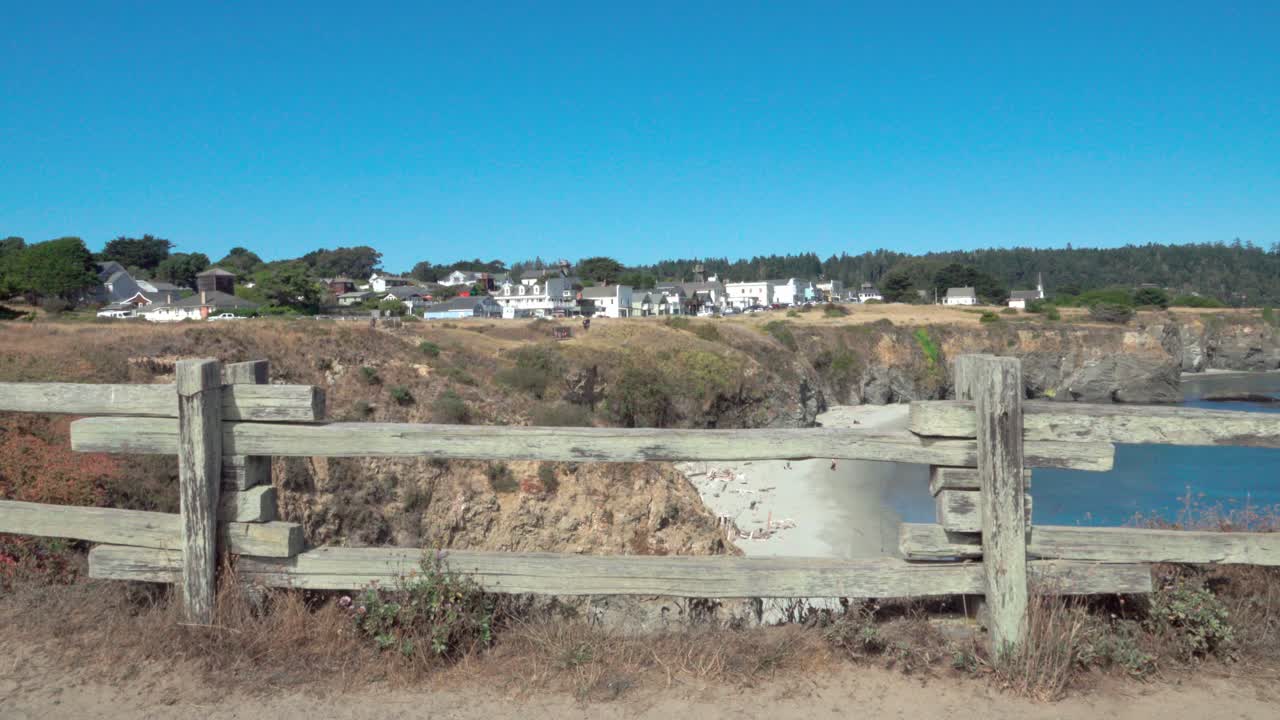 hermosa valla de madera rodada enmarca un día de cielo azul vista de una pequeña playa y edificios históricos mendicino ca 2