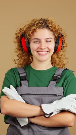 smiling woman in work overalls with hearing protection