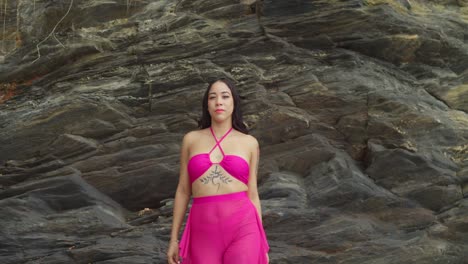 the tropical island beach in trinidad is enjoyed by a hispanic girl in a pink bikini