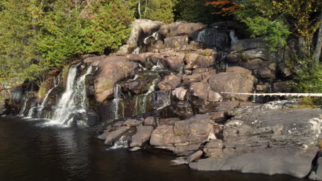 Hermosa-Cascada-En-Las-Rocas-Fluye-Hacia-El-Río,-Los-Arroyos-Del-Bosque-Fluyen-Por-Las-Rocas