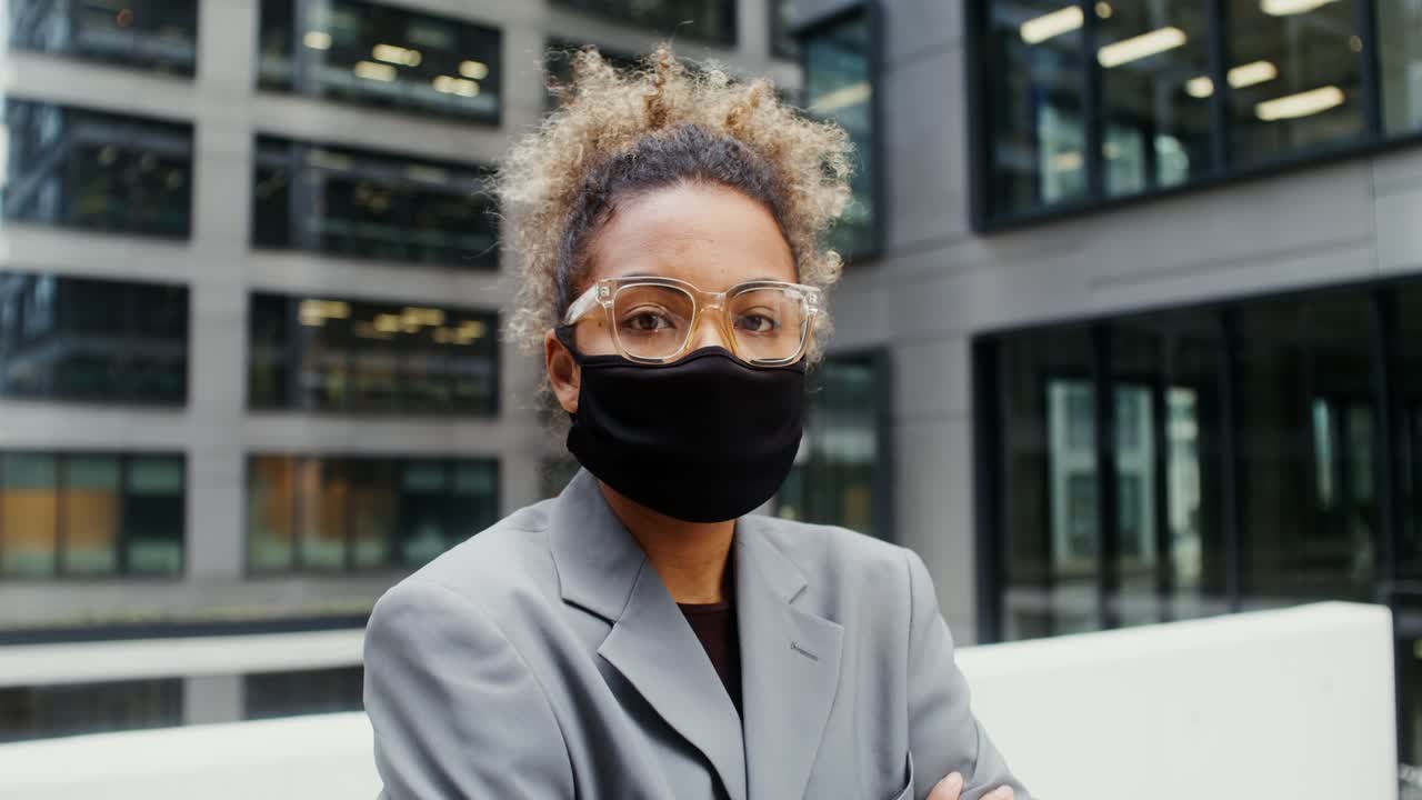 Woman in Face Mask and Glasses in front of Office Building