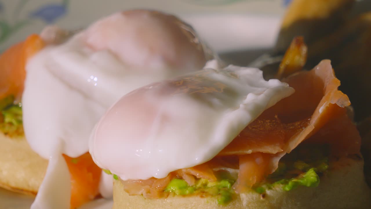 Early Morning Quality Delicious Breakfast of Avocado on Crumpet with Smoked Salmon Topped with Poached Egg. High Protein Healthy Stylish Food Brunch Footage 4K.