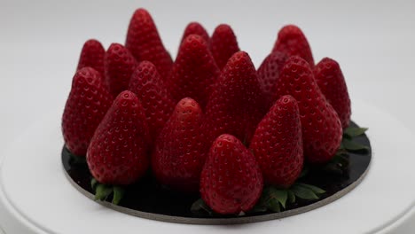 Fresh-ripe-strawberries-on-white-display-rotating