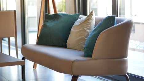 sofá beige moderno con almohadas azules y beige