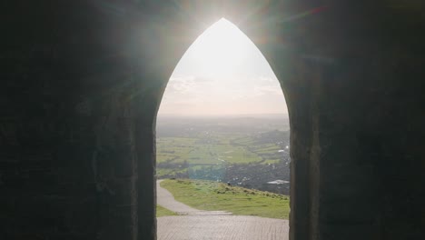 dolly shot from inside a gothic church through doorway to beautiful green landscape with nice sunlight