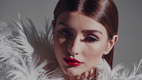 close-up portrait of woman with white feathers and red lips