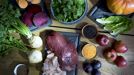 fresh raw meat and vegetables cooking ingredients on a kitchen table