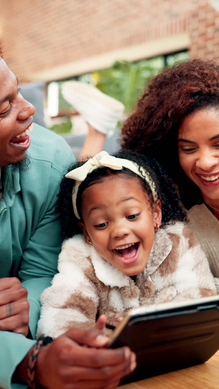 Famiglia afroamericana felice che guarda il tablet insieme