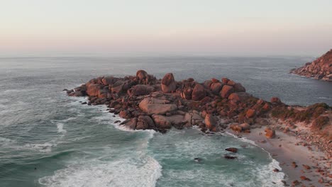 Olas-Rompiendo-Sobre-Rocas-De-Granito-Al-Atardecer-En-La-Playa-De-Llandudno,-Ciudad-Del-Cabo,-Sudáfrica