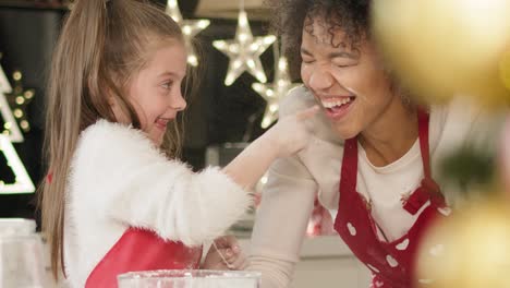 handheld view of mother and her daughter enjoying in kitchen