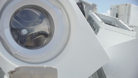 discarded household washing machines and e-waste at disposal center, closeup