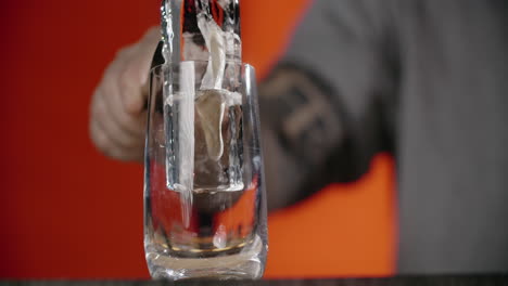 bartender pouring ice into a glass