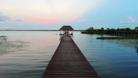 wooden boardwalk leads to tropical cabana hut at end looking over serene ocean