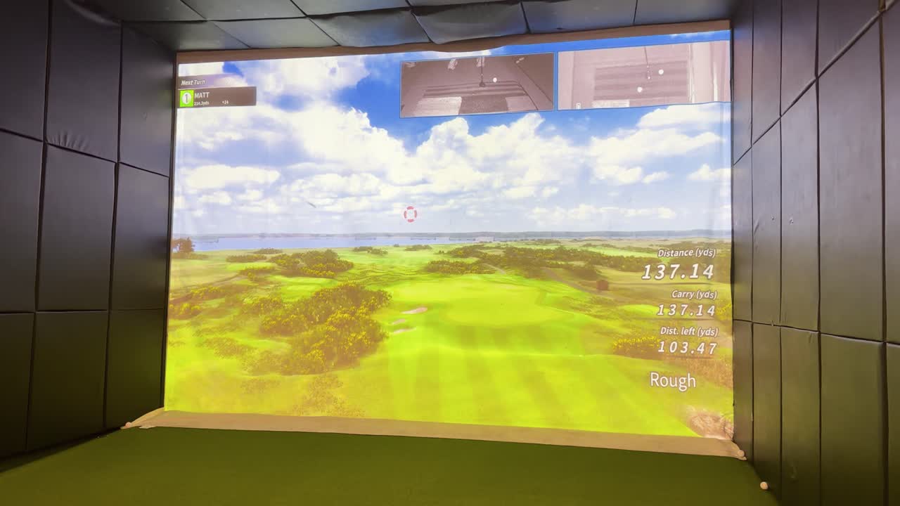 A golfer practices on a virtual driving range using an indoor simulator with realistic graphics