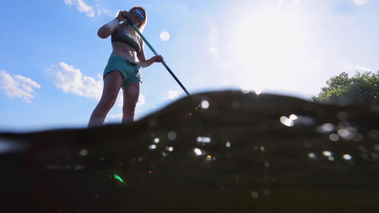 예쁜 소녀는 물을 통해 패들링 탑승 slomo 일어 서서