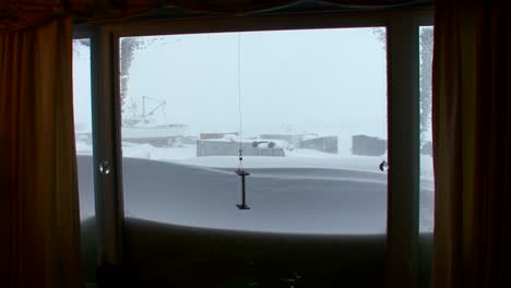 a view out of a living room window of a arctic blizzard