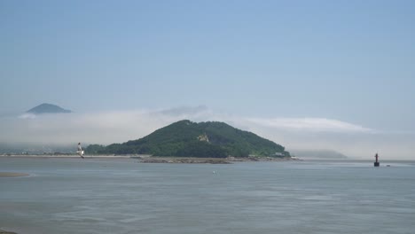 Seagulls-flying-over-the-Yellow-Sea-near-Ganghwado-island,-South-Korea,-Red-navigational-buoy-floating-in-Yellow-sea-between-islands,-static-seaside-panorama