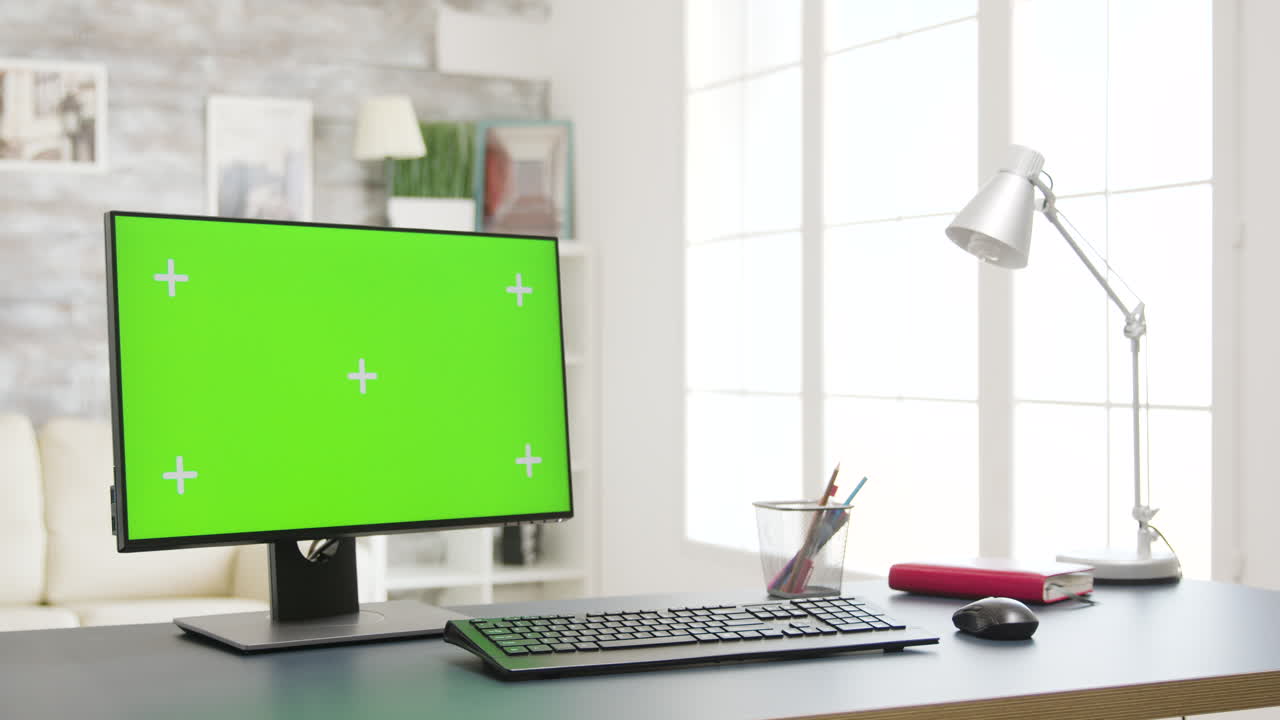 Workspace with computer and green screen